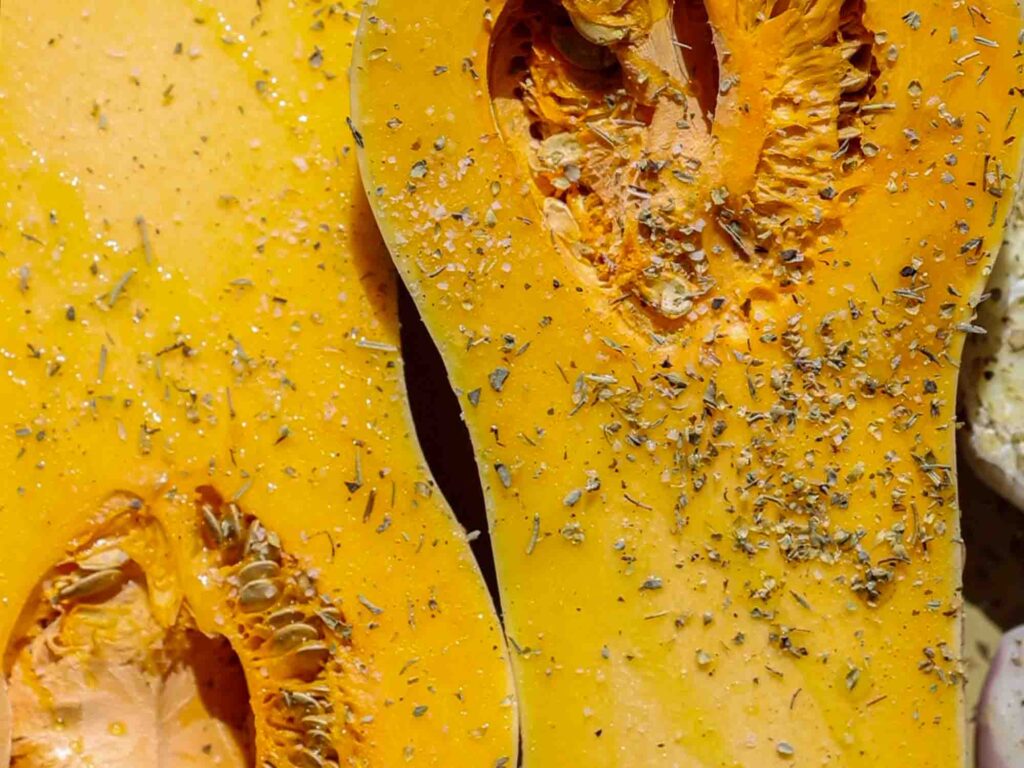 close up shot of seasoned butternut squash before it goes into oven